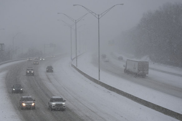 Vehicles drive along a highway during a winter storm in Cincinnati.