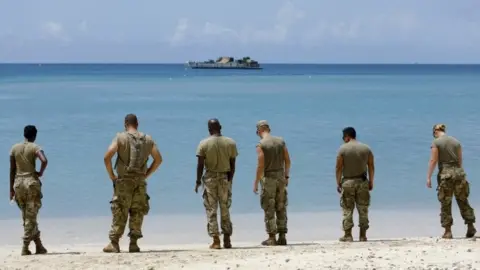 Reuters US soldiers wait on a beach for a navy landing craft as their unit evacuates in advance of Hurricane Maria, in Charlotte Amalie, St Thomas, US Virgin Islands. Photo: 17 September 2017