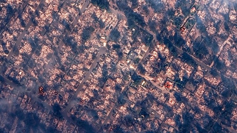 A satellite image shows smoke covering houses after devastating wildfires, in Altadena, California
Pic: Maxar/Reuters