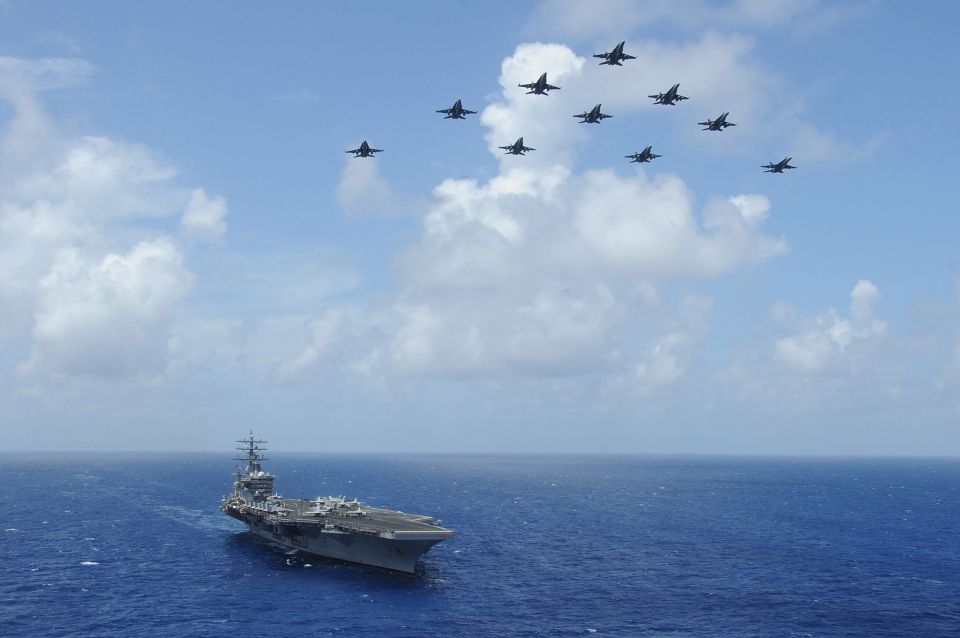 F/A-18C Hornets fly over the USS Dwight D. Eisenhower.