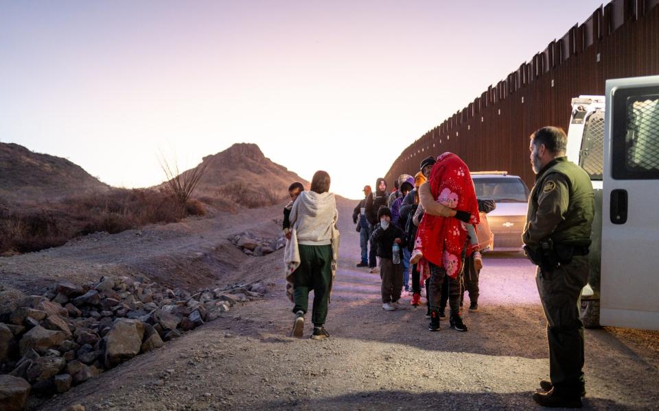 Migrants turn themselves in to U.S. Customs and Border Patrol officers after crossing over a section of border wall into the U.S. on January 05, 2025 in Ruby, Arizona