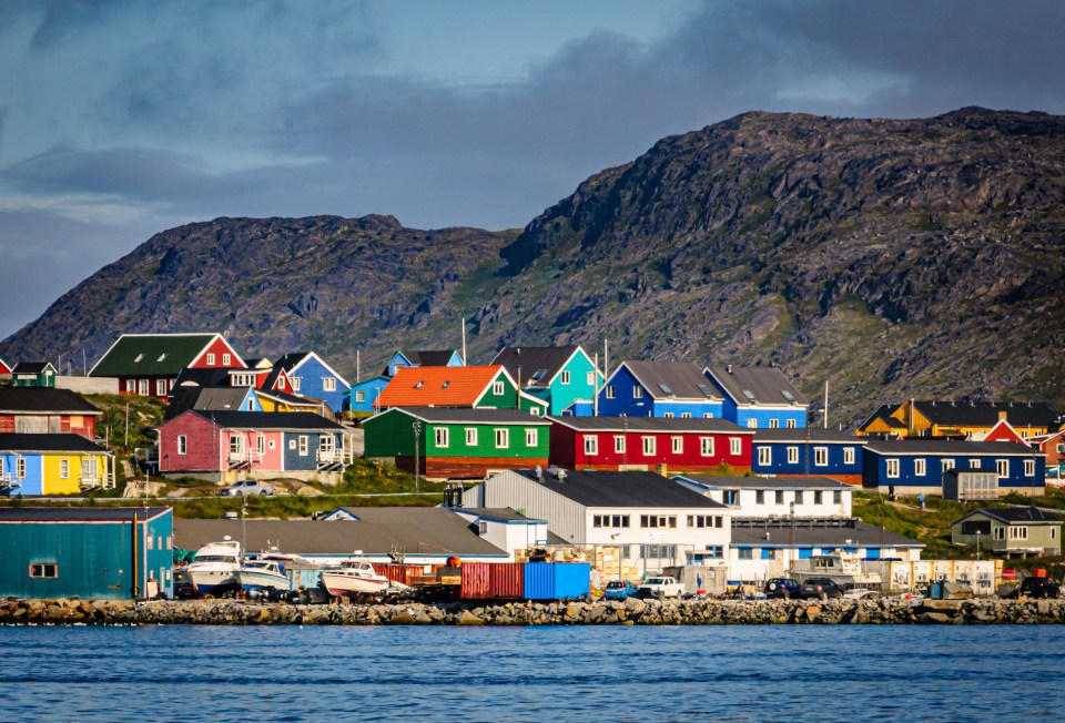 Colorful houses on a hillside overlooking a harbor.