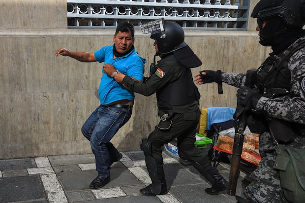 Un simpatizante del expresidente Evo Morales es detenido por un miembro de la policía boliviana durante una marcha en contra de los procesos judiciales al exmandatario, en La Paz, Bolivia, el 13 de enero de 2025. (Foto de Gabriel Márquez / EFE)