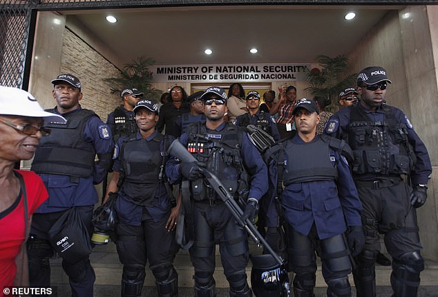 Police officers stand guard outside the Ministry of National Security in Port of Spain, Trinidad and Tobago's capital, where there were multiple shootings on the final weekend of 2024