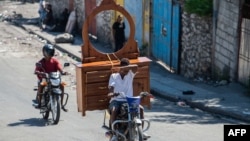 FILE - People flee their neighborhood after armed gangs terrorized the Delmas 24 and Solino areas in Port-au-Prince, Haiti, Oct. 26, 2024.