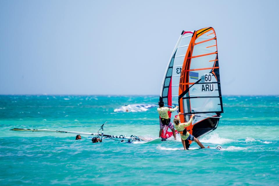 A couple of windsurfers in the ocean.