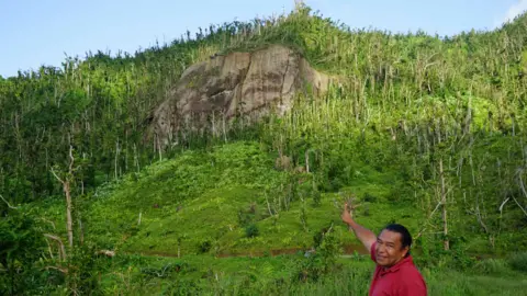 Gemma Handy Former Kalinago Chief Irvince Nanichi Auguiste points at White Horse Rock