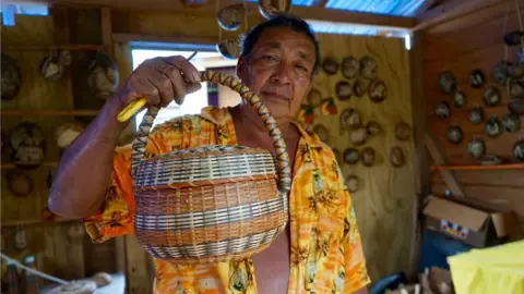 Gemma Handy Willard Bruney shows off a basked a has woven