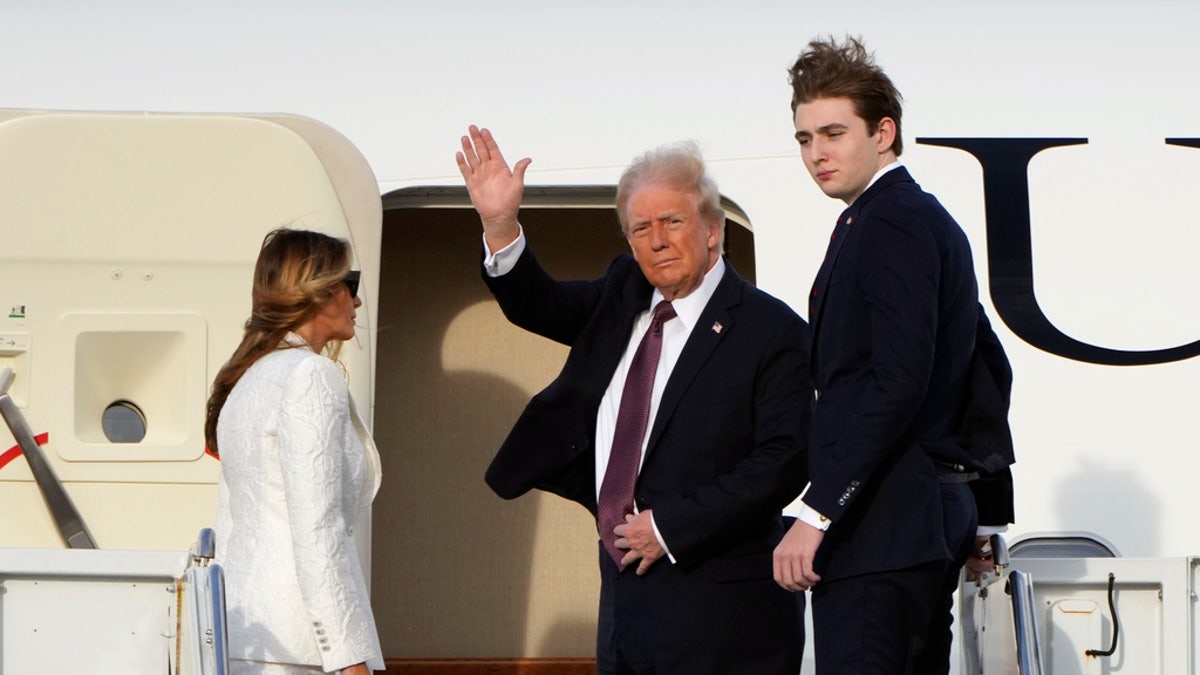 President-elect Donald Trump, standing with Melania and Barron Trump, waves as they board an Air Force Special Mission airplane at Palm Beach International Airport Saturday, Jan. 18, 2025 in West Palm Beach, Fla., en route to Washington.