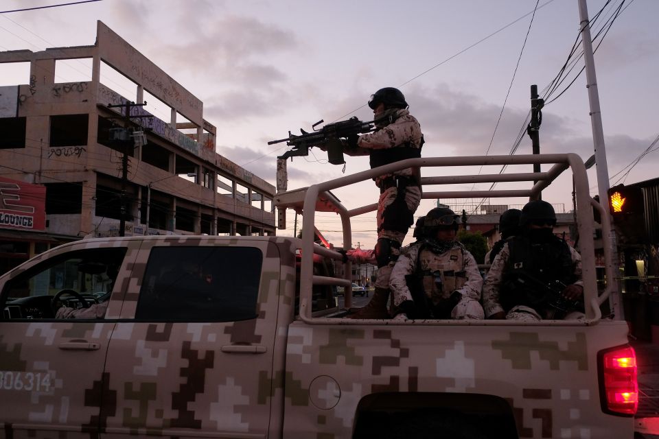 Mexican soldiers in a truck at a crime scene.