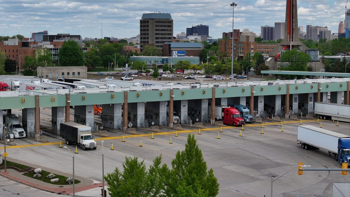 Trucks drive across the border from Detroit back into Canada.