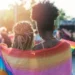 Getty Images Young female couple hugging with rainbow scarf at pride event