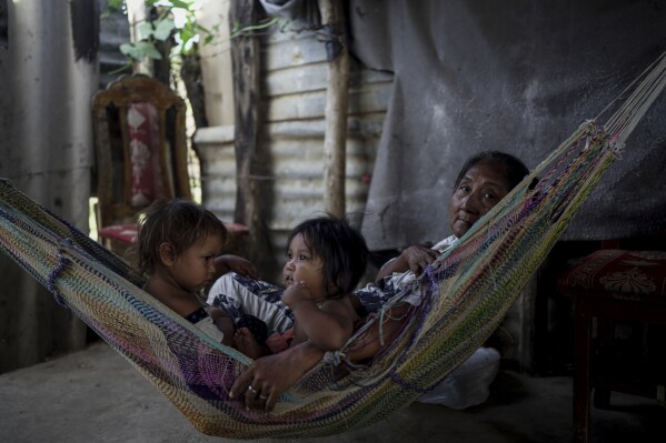 An Indigenous Wayuu family rests in a chinchorro, a handmade hammock, in the Belen neighborhood on the outskirts of Riohacha, Colombia, Tuesday, Feb. 4, 2025. (AP Photo/Ivan Valencia)