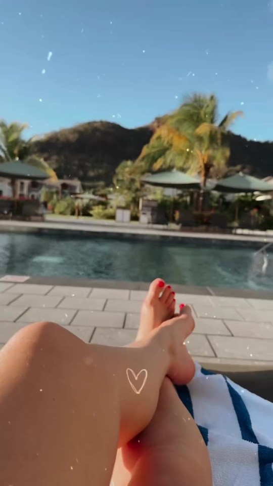 Person's legs by a pool with a heart drawn on their leg.