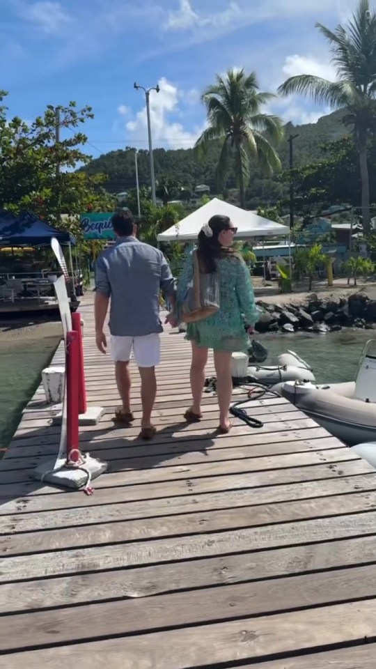 Couple walking hand-in-hand on a dock.