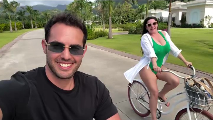 Kelly Brook riding a bicycle in a green swimsuit.