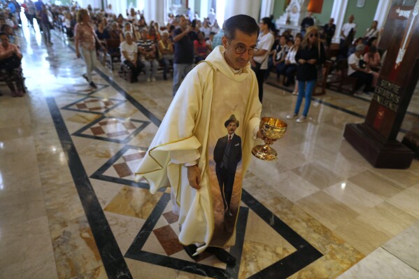 Father Gregory Lobo wears a chasuble designed with an image of Dr. Jose Gregorio Hernandez during a celebratory Mass in Caracas, Venezuela, Tuesday, Feb. 25, 2025, after Pope Francis approved the canonization of the physician known as the 