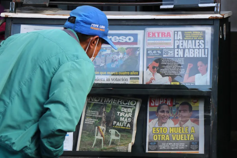 A man reads front pages about the first round of Ecuador’s presidential election at a newspaper kiosk in Quito on Feb. 10.