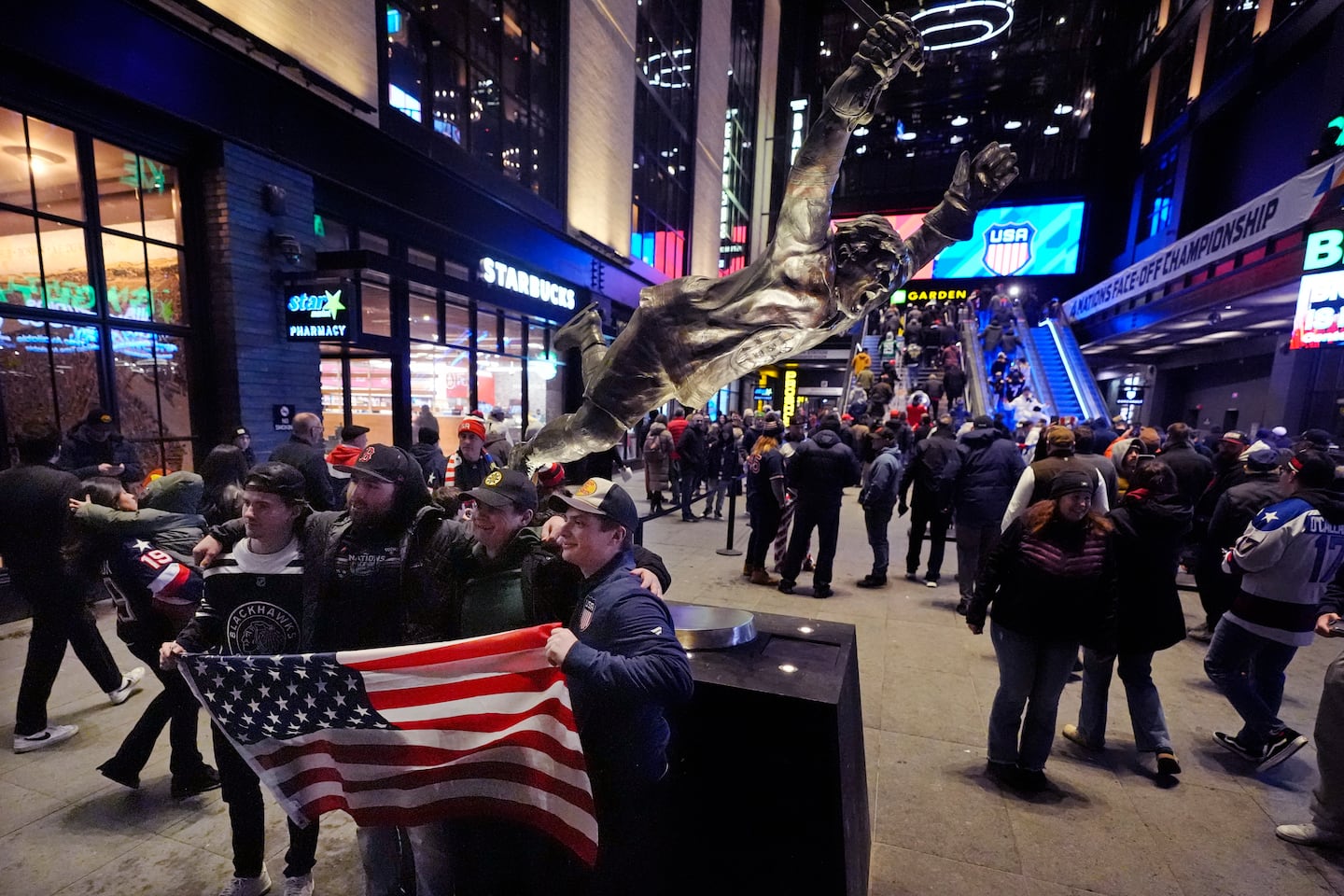 Fans unfurl an American flag next to the statue of NHL Hall of Famer Bobby Orr prior to the 4 Nations Face-Off championship game at TD Garden.