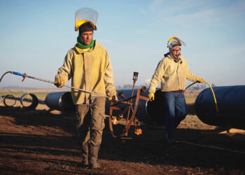 Workers carry equipment during the construction of the Nestor Kirchner gas pipeline.