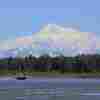 A boat is seen on the Susitna River near Talkeetna, Alaska, with Denali in the background in June 2021.