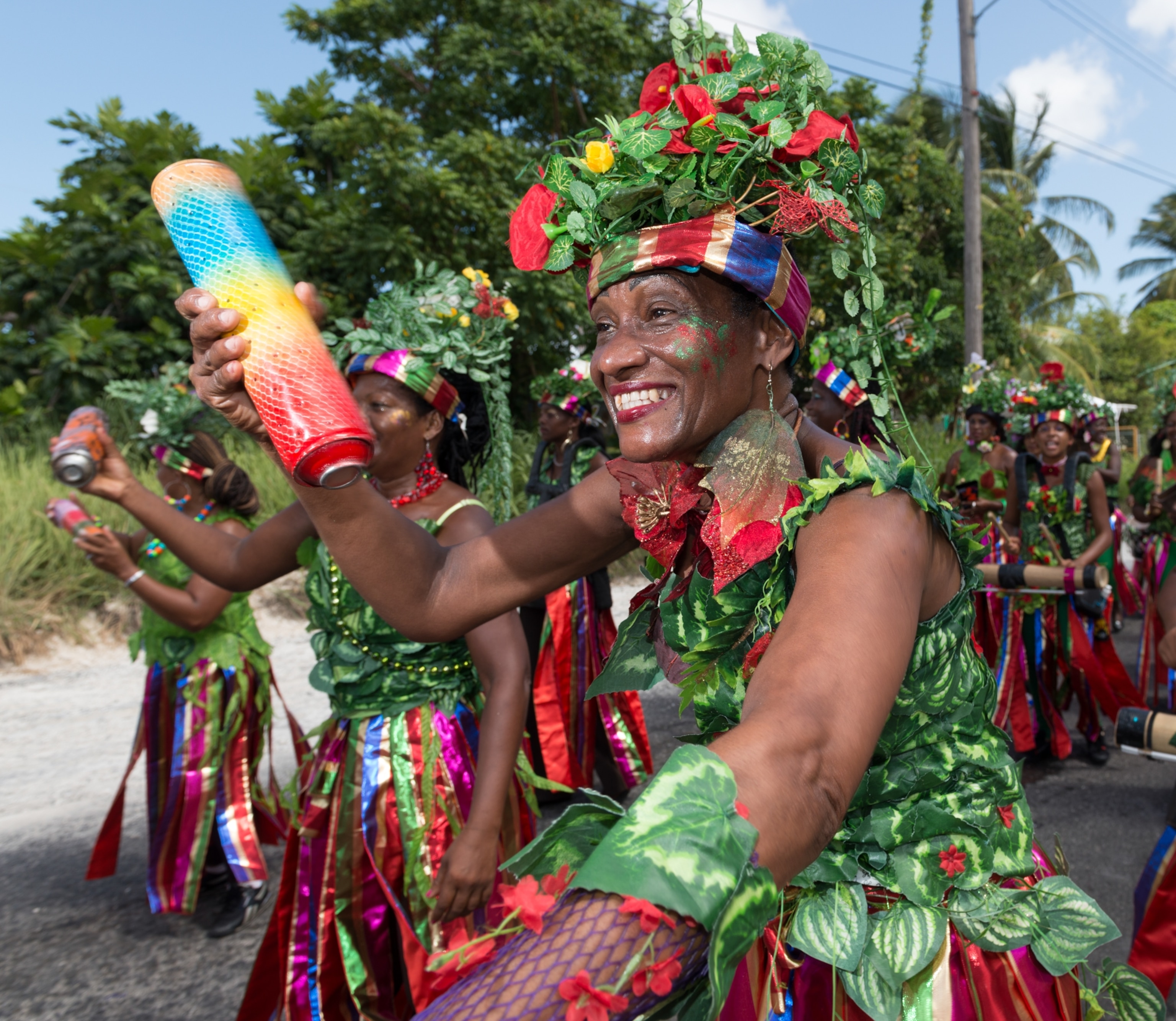 A close up of a woman in green and red with an instrument in hand.